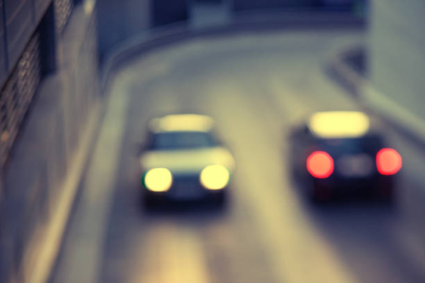 Two cars with white lights and red lanterns are going to meet each other