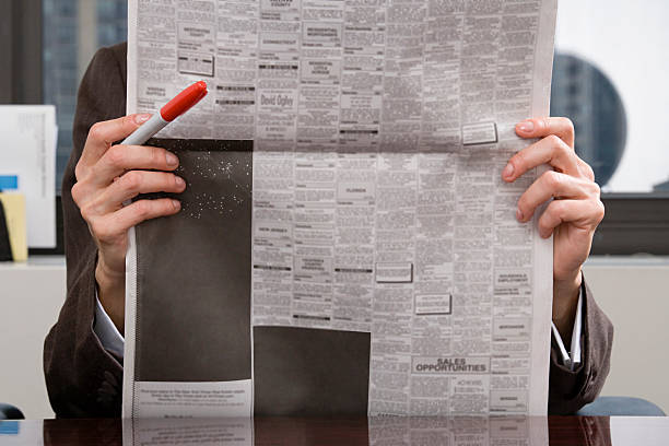 person, blick in die zeitung - classified ad newspaper advertisement job stock-fotos und bilder