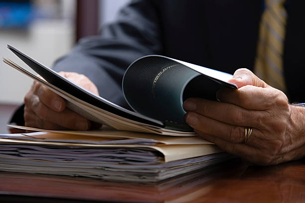 hombre de negocios mirando documentos - carpeta de anillas fotografías e imágenes de stock