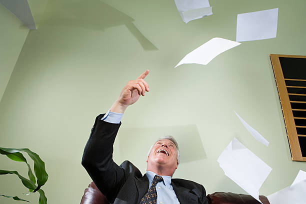 istock Businessman throwing paper in the air 532606153