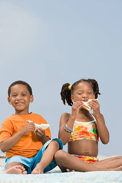 Brother and sister eating sandwiches