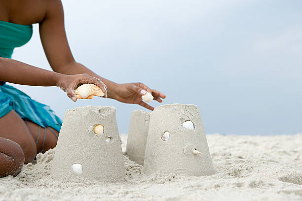 istock Mother and child putting shells on sandcastles 532606181