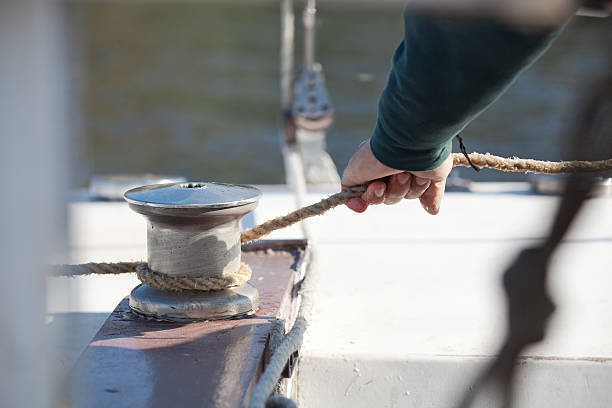 istock Hand pulls the rope around winch of sailboat closeup 532606955