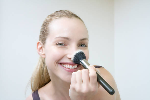 istock Young woman using make-up brush, smiling, portrait 532608007
