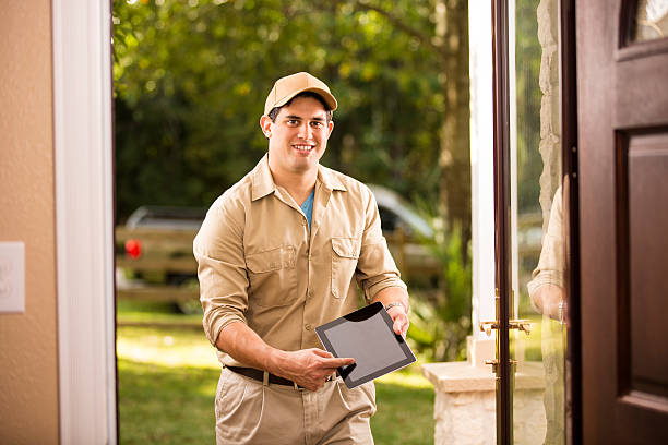 istock Service: Latin descent repairman at customer's front door. Digital tablet. 532611025