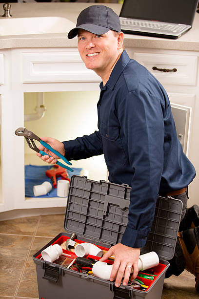 istock Plumber, repairman working under sink in home kitchen. 532611031