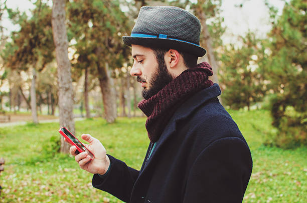 istock Handsome hipster modern man using smart phone in the park 532624581