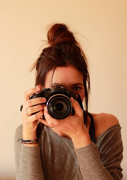 istock Young female photographer with camera on soft background 532643139