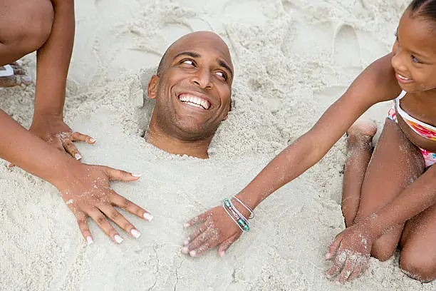 Family burying father in sand
