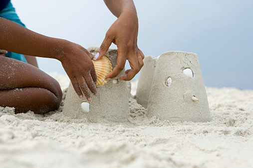 Mother and child putting a shell on a sandcastle