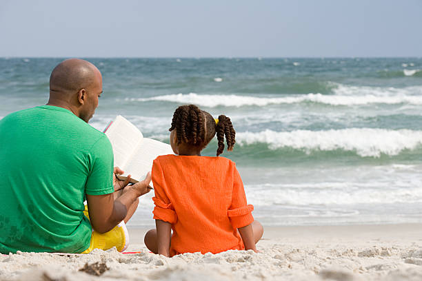 pai e filha a ler - reading outside imagens e fotografias de stock
