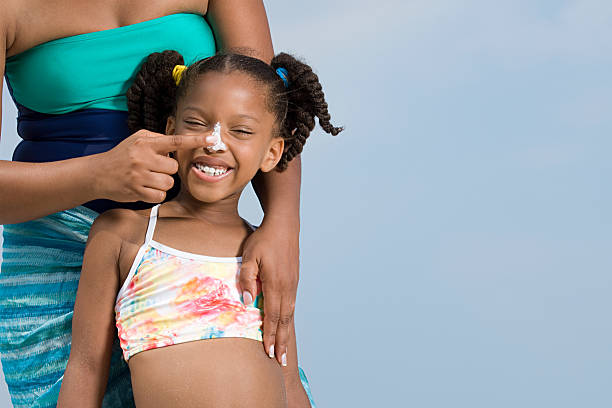 mulher aplicando suncream para filhas nariz - mother holding child pointing imagens e fotografias de stock