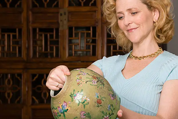 Photo of Woman looking at a vase