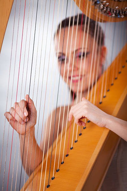 istock Young woman playing harp 532647269