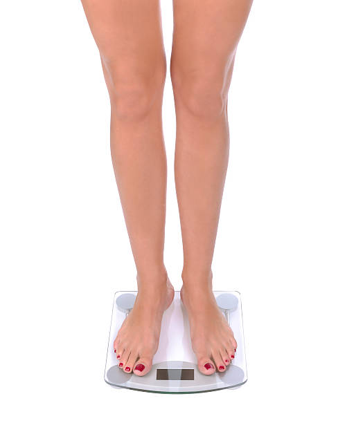 donna e bilancia da bagno - emaciated weight scale dieting overweight foto e immagini stock