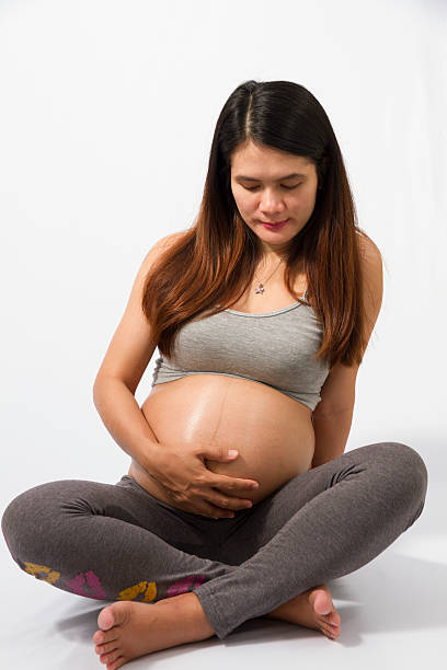 istock pregnant woman caressing her belly over white background 532665169