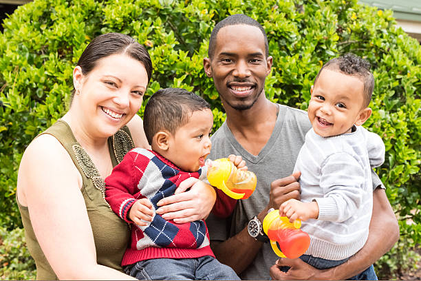 Smiling caucasian wife posing with her afro caribbean husband and their two children