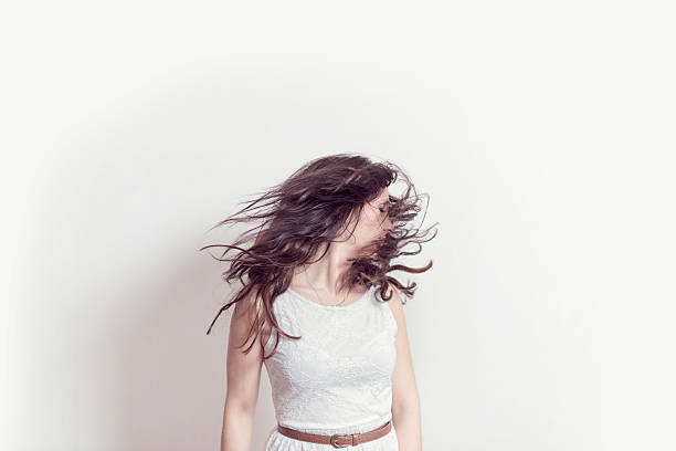 Portrait of Beautiful Young Woman Shaking Her Hair Over White Background