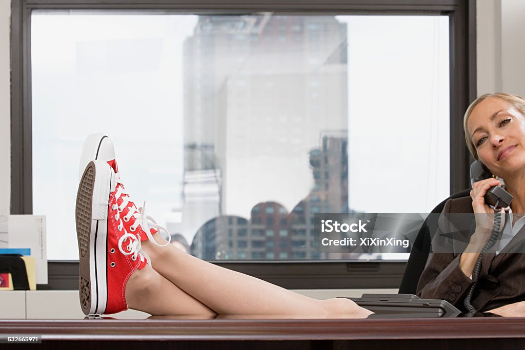 Businesswoman wearing baseball boots Eccentric Stock Photo