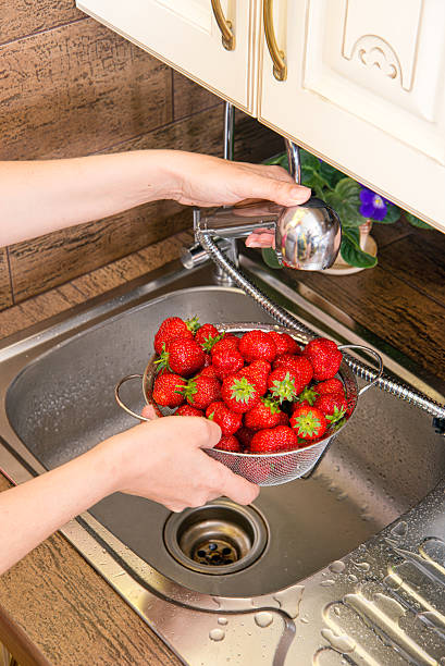 istock girl washes strawberries 532667091