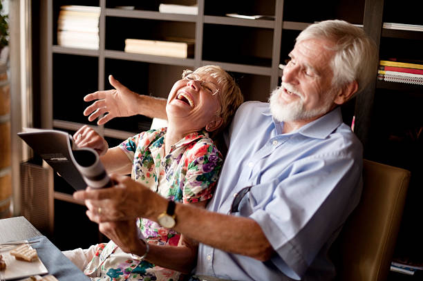 счастливый пожилая пара, читать журнал в баре - real people humor close up affectionate стоковые фото и изображения