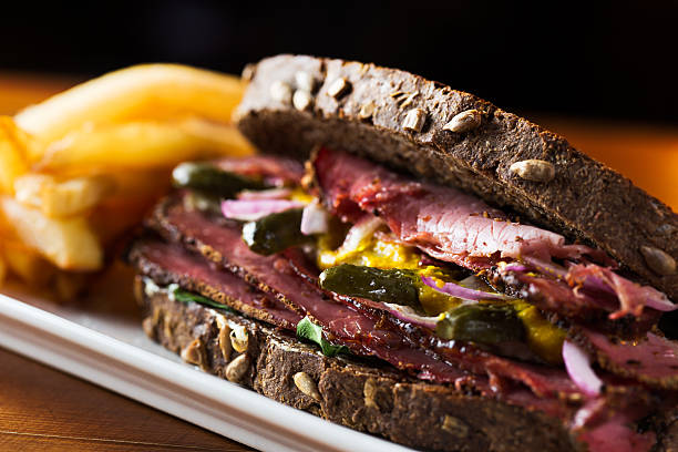Pastrami Delicious pastrami sandwich with french fries ready to eat. reuben sandwich stock pictures, royalty-free photos & images