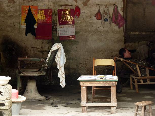 Fuli', China - April 28, 2014: Man sitting at a local barber shop in Fuli' traditional village, a small settlement near the popular Yangshuo in Guangxi region.