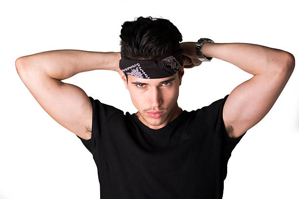 Handsome young man tying headband around head Handsome young man tying headband around head looking at camera, isolated on white bandana photos stock pictures, royalty-free photos & images