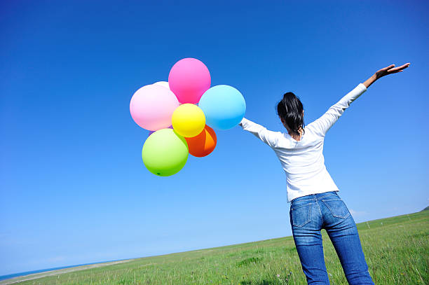 istock young asian woman  with colored balloons 532700025
