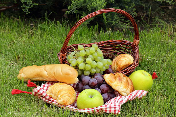 istock picnic on green grass with grapes,apples and croissants 532701789