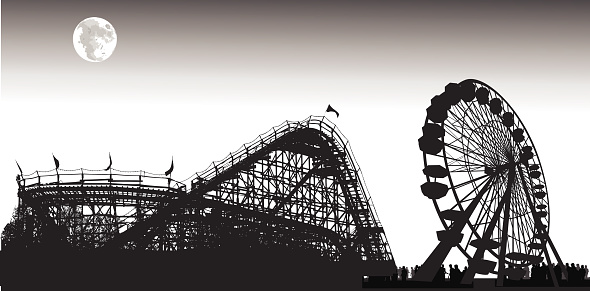 A rollar coaster and ferris wheel at dusk under the moolight.