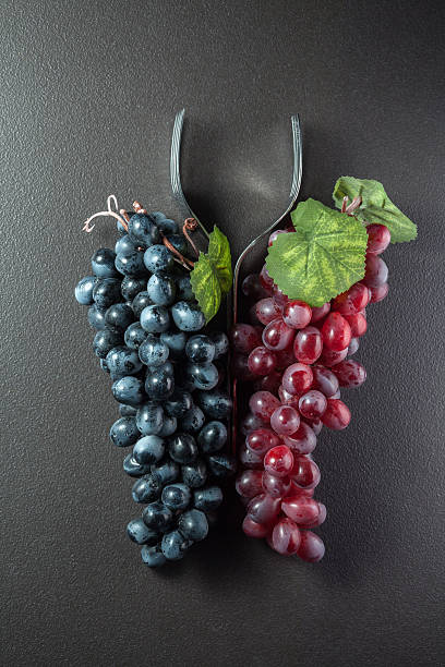 istock Wine glass made of forks and grape on black 532703181
