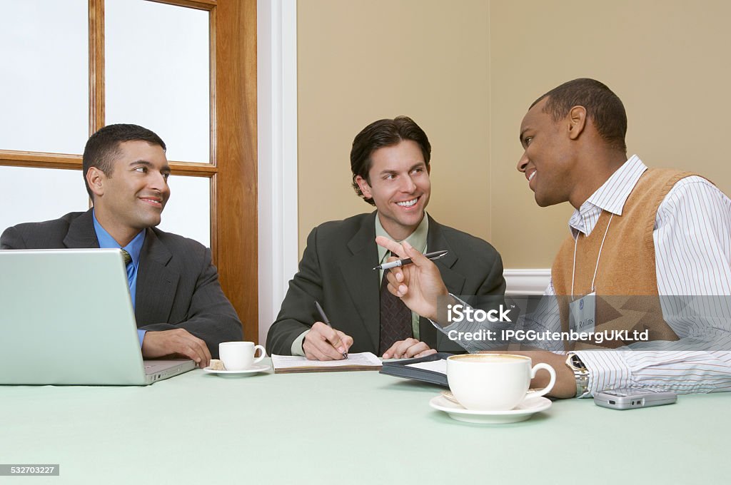 Business people at meeting Three business men talking at desk 2015 Stock Photo