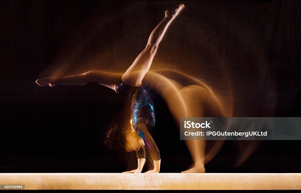Young Gymnast Gymnast Doing Cartwheel on Balance Beam Gymnastics Stock Photo