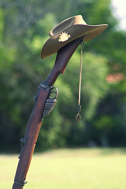 ANZAC Australian Army 303 Rifle, Slouch Hat and Dog tags On ANZAC Day, an upturned Australian Army 303 Rifle stands embedded in the ground with a digger's slouch hat and dogtags swaying in the breeze. larrikin stock pictures, royalty-free photos & images