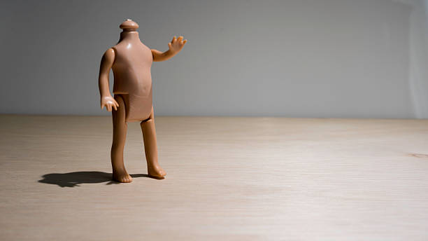 istock Headless doll body on wooden surface with room for text 532747655