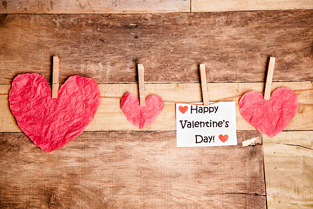 istock Paper hearts on string. Happy Valentine's Day note. Wooden table. 532754401