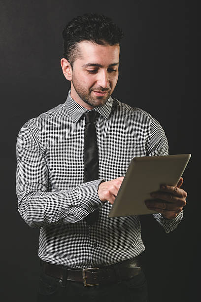 istock Young Man Typing on Digital Tablet, Black Background 532769361
