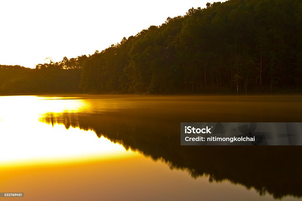 morning light with the silhouette of the mountain and reflection morning light with the silhouette of the mountain and reflection on the water at Pang Ung Forestry  Plantations,Maehongson, North of Thailand 2015 Stock Photo