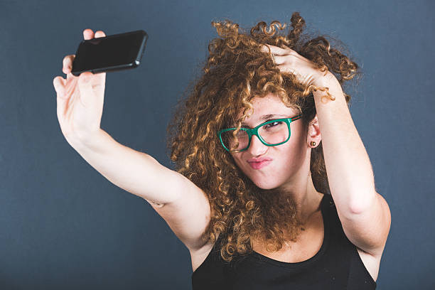 istock Smiling Curly Woman Taking Selfie 532769635