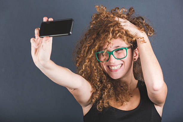 istock Smiling Curly Woman Taking Selfie 532769647