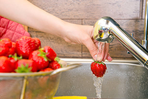 istock girl washes strawberries 532771365