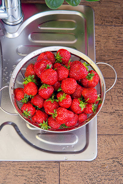 istock girl washes strawberries 532771377