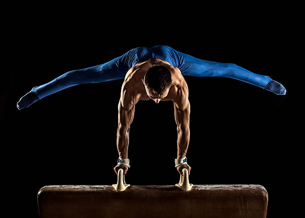 Male Gymnast doing handstand on Pommel Horse Male Gymnast doing handstand on Pommel Horse artistic gymnastics stock pictures, royalty-free photos & images