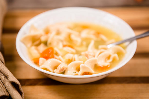 istock Chicken noodle soup in bowl. Spoon. Wooden cutting board. 532788355