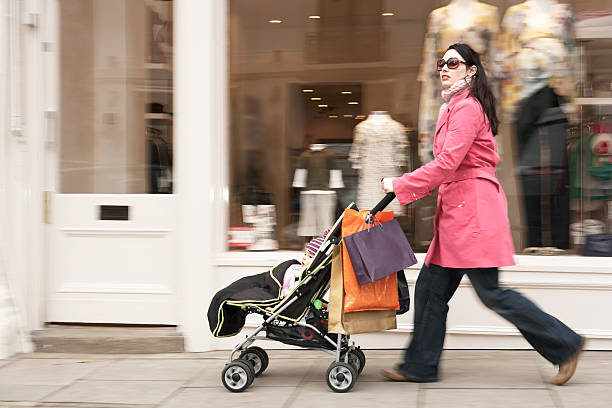 istock Mother Pushing Stroller By Clothes Shop 532789313