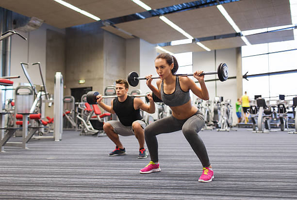 jovem e mulher treino com barra na academia de ginástica - weight training body building men human muscle - fotografias e filmes do acervo