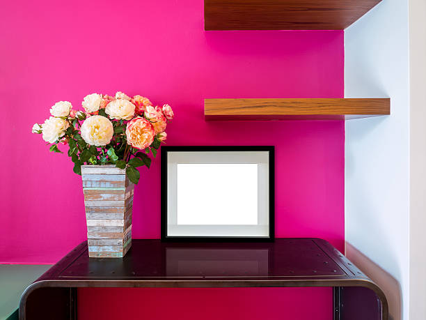 Modern interior wall with flowers vase and blank picture frame stock photo