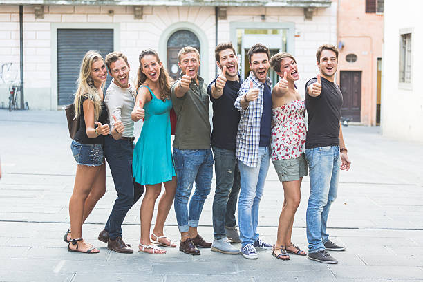 Group of Friends with Thumbs Up. They're all in a line showing right hands with thumbs up.