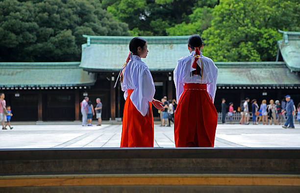 Tokyo, Japan - August 28, 2014: Maidens in traditional gowns at the Meiji Shrine, a Shinto complex in Tokyo dedicated to the Emperor Meiji and his wife, Empress Shōken. Completed in 1926, it is situated in 175 acres of forests in Yoyogi Park.